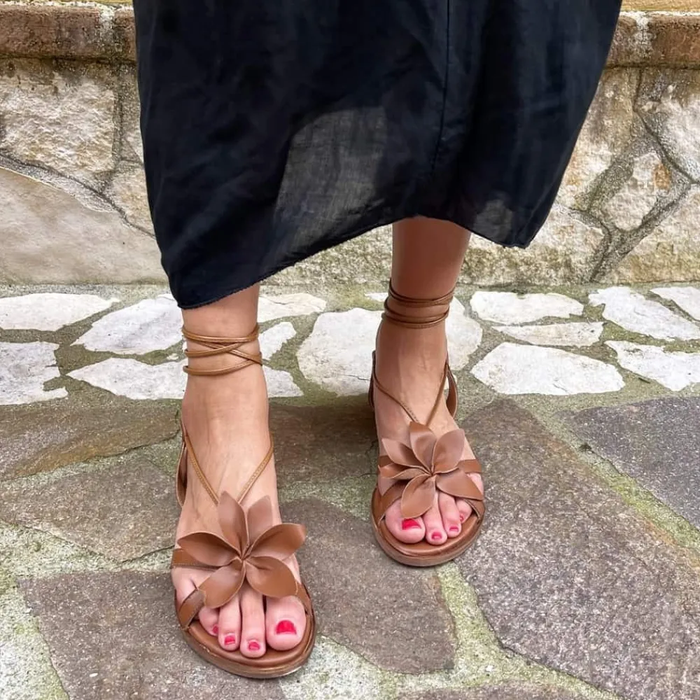 sandali_bassi_con_laccio__1-1.webp Sandali Bassi | In Time Sandali Bassi con Laccio alla Caviglia e Fiore "Petalo" - Pelle Cuoio