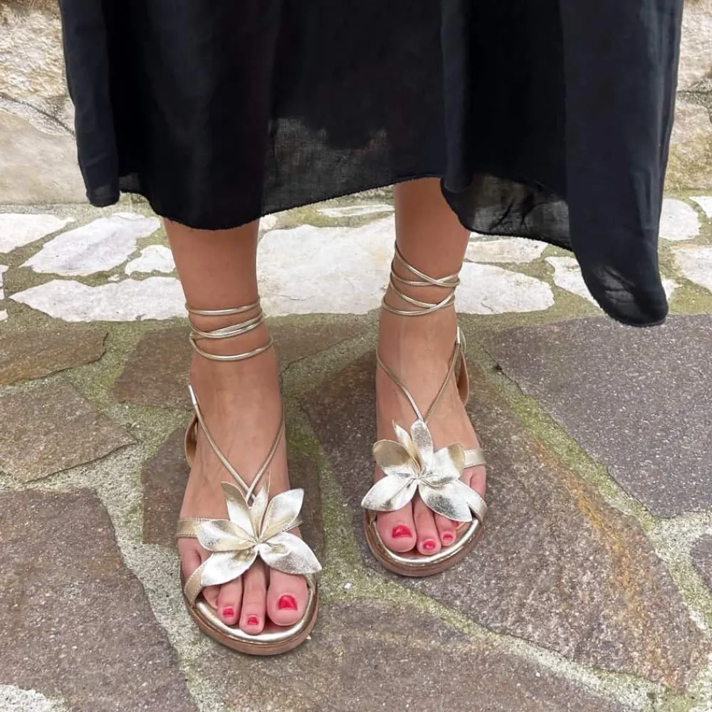 sandali_bassi_con_laccio__1.webp Sandali Bassi | In Time Sandali Bassi con Laccio alla Caviglia e Fiore "Petalo" - Platino